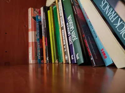 a row of books sitting on a shelf at Charles Bridge Hostel & Apartments in Prague