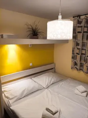 a bed in a room with a shelf above it at Charles Bridge Hostel & Apartments in Prague