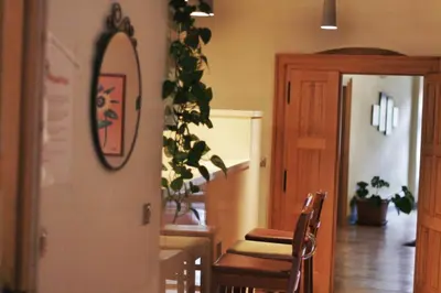 a dining room with a table and chairs and a mirror at Hostel HOMEr - Old Town Square in Prague