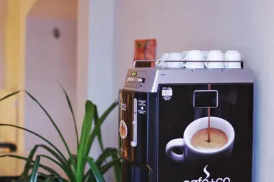 a coffee machine with a cup of coffee at Hostel HOMEr - Old Town Square in Prague