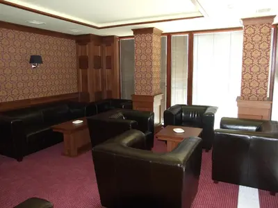 a waiting room with black leather chairs and tables at Hotel Beroun Golf Club in Beroun