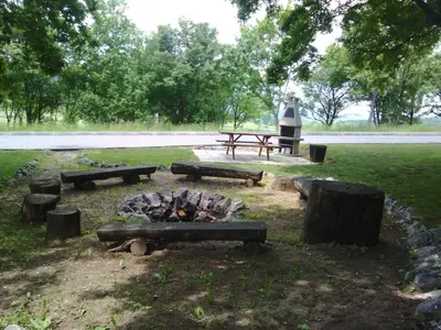 a fire pit and picnic tables in a park at Hotel Beroun Golf Club in Beroun