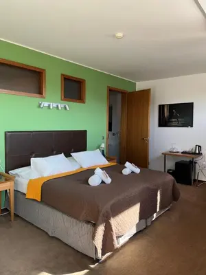 a bedroom with a large bed with towels on it at Hotel Beroun Golf Club in Beroun