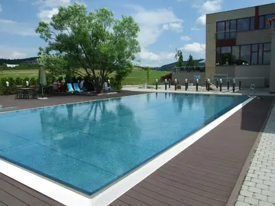 a swimming pool in front of a building at Hotel Beroun Golf Club in Beroun