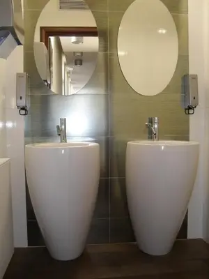 a bathroom with two sinks and two mirrors at Art Hotel Podebrady in Poděbrady