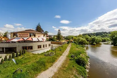 a building on the side of a river next to a building at Hostel Příběh in Týnec nad Sázavou