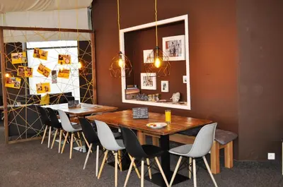 a dining room with two tables and chairs and a mirror at Hostel Příběh in Týnec nad Sázavou