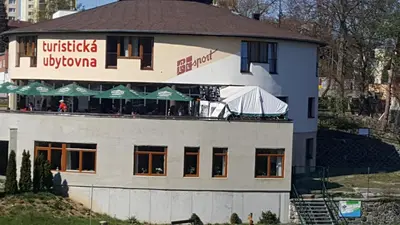 a building with a restaurant on top of it at Hostel Příběh in Týnec nad Sázavou