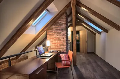 an attic office with a desk and a window at Residence Rybna in Prague