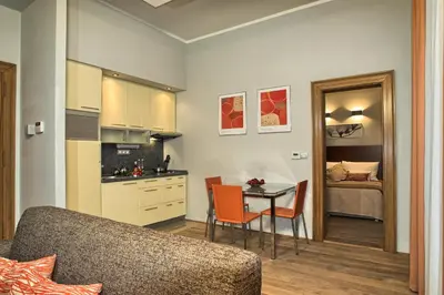 a living room with a kitchen and a table with chairs at Residence Rybna in Prague