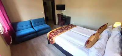 a bedroom with a bed and a blue couch at Sun-House Pension - ParkingFree Limited spaces- in Prague
