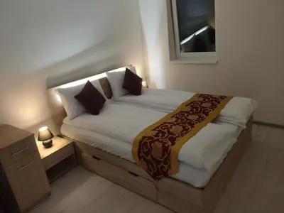 a small bedroom with a bed with white sheets and pillows at Sun-House Pension - ParkingFree Limited spaces- in Prague