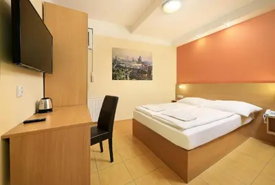a bedroom with a bed and a desk with a television at Basement Room Old Town in Prague