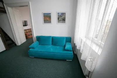 a blue couch in a room with a window at Apartment Kahoun in Prague