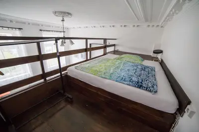 a small bedroom with a bed in a room with windows at Apartment Kahoun in Prague