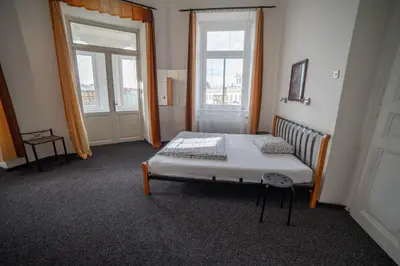 a bedroom with a bed and two windows at Apartment Kahoun in Prague