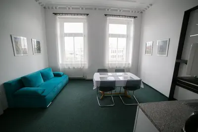 a living room with a blue couch and a table at Apartment Kahoun in Prague