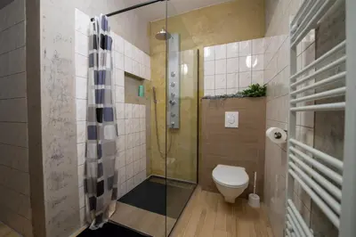 a bathroom with a toilet and a glass shower at Apartmány Caffe & Grill in Roudnice nad Labem