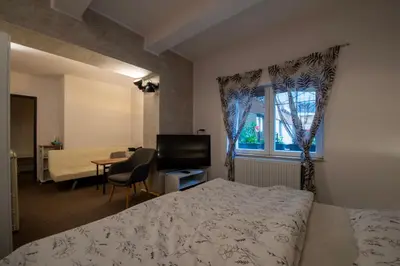 a bedroom with a bed and a window and a desk at Apartmány Caffe & Grill in Roudnice nad Labem