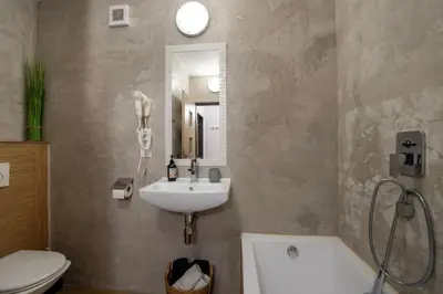a bathroom with a sink and a toilet and a mirror at Apartmány Caffe & Grill in Roudnice nad Labem