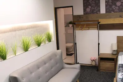 a living room with a couch and plants on the wall at Apartmány Caffe & Grill in Roudnice nad Labem