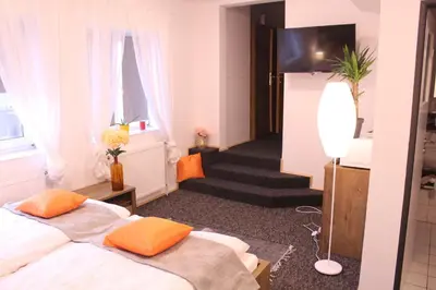 a hotel room with two beds and a hallway at Apartmány Caffe & Grill in Roudnice nad Labem