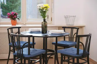 a table with four chairs and a vase with flowers at Pawlansky Residence in Prague