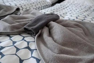 a blanket laying on top of a bed at Pawlansky Residence in Prague