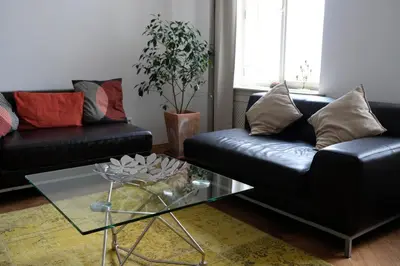 a living room with two black couches and a glass table at Pawlansky Residence in Prague