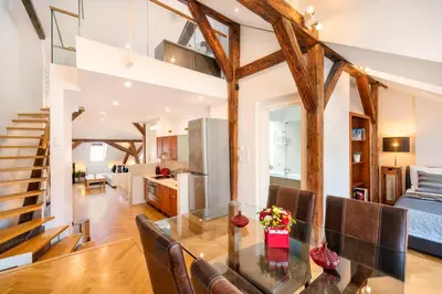 a dining room and living room with wooden beams at Old Town Square Premium Residence in Prague