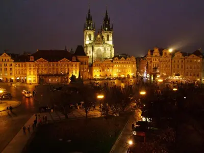 a city lit up at night with a clock tower at Old Town Square Premium Residence in Prague