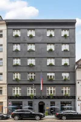 a gray building with cars parked in front of it at Numa Prague Republika in Prague
