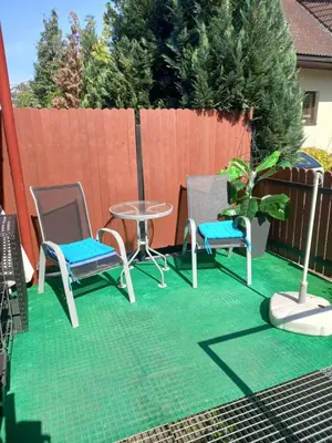 a patio with two chairs and a table and a plant at App Tony Beroun in Beroun