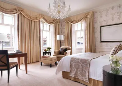 a bedroom with a bed and a desk and a chair at Four Seasons Hotel Prague in Prague