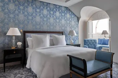a bedroom with a large bed and a blue wall at Four Seasons Hotel Prague in Prague