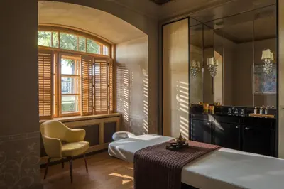 a bedroom with a bed and a chair and a window at Four Seasons Hotel Prague in Prague