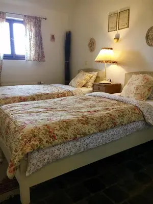 a bedroom with two beds and a lamp and a window at Penzion V polích in Malé Číčovice