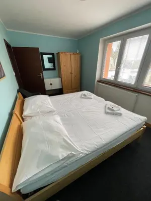 a room with two beds and a tv on the wall at Hotel Max in Prague