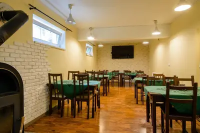 a dining room with green tables and chairs and a tv at Hotel Max in Prague