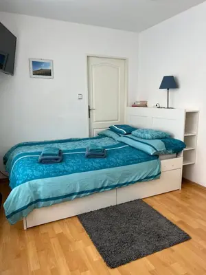 a bedroom with a large bed with blue sheets at Celý dům v historickém centru Loun in Louny
