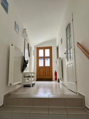 a hallway with a wooden door and a staircase at Celý dům v historickém centru Loun in Louny