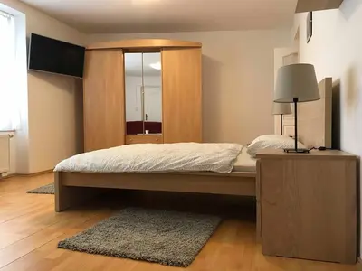 a bedroom with a large bed with a wooden headboard at Celý dům v historickém centru Loun in Louny