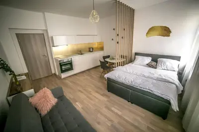 a bedroom with a large bed and a kitchen at Prague friendly apartments in Prague in Prague