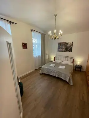 a large bedroom with a bed and a chandelier at Prague friendly apartments in Prague in Prague
