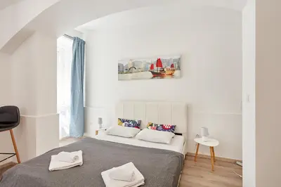 a white bedroom with a bed and a painting on the wall at Prague friendly apartments in Prague in Prague