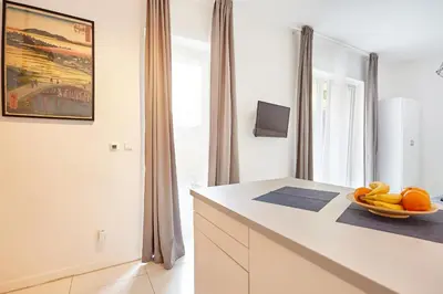 a white kitchen with a bowl of fruit on a counter at Prague friendly apartments in Prague in Prague