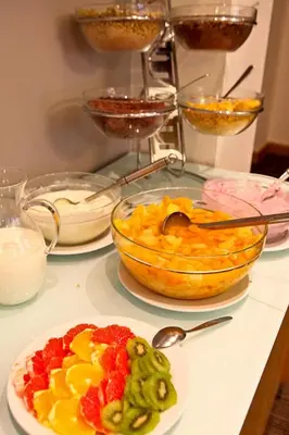 a counter with a bowl of fruit and a plate of food at Central Hotel Prague in Prague