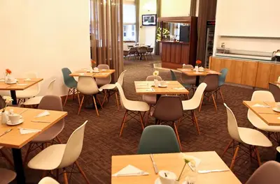 a restaurant with wooden tables and chairs in a room at Central Hotel Prague in Prague