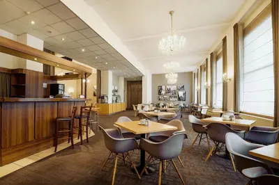 a restaurant with tables and chairs and a bar at Central Hotel Prague in Prague