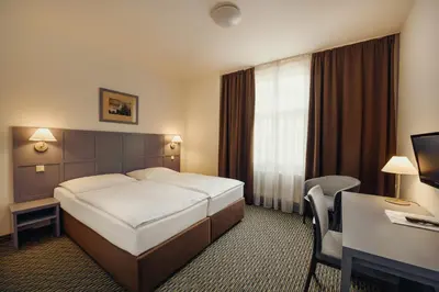 a hotel room with a bed and a desk at Central Hotel Prague in Prague